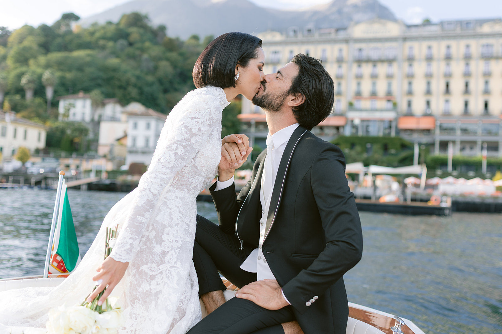 bride and groom kissing inside a boat in Lake Como with Grand Hotel Tremezzo as a backdrop