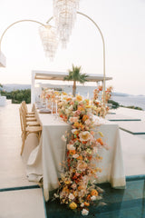 Decorated table with floral arrangement and chandelier in an outdoor setting
